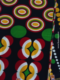 Pagne wax noir avec des motifs géométriques rouges, jaunes & verts